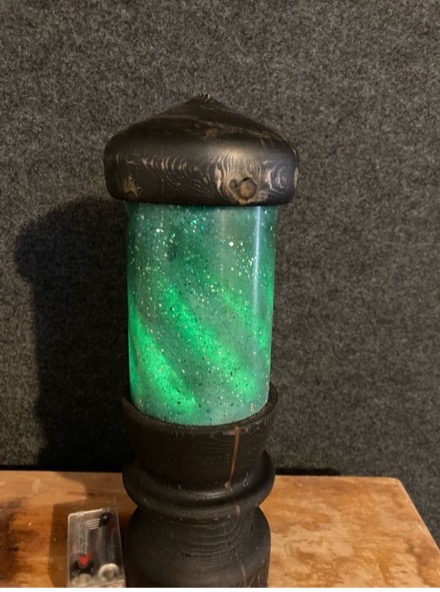 Lamp made from wooden spiral surrounded by green resin